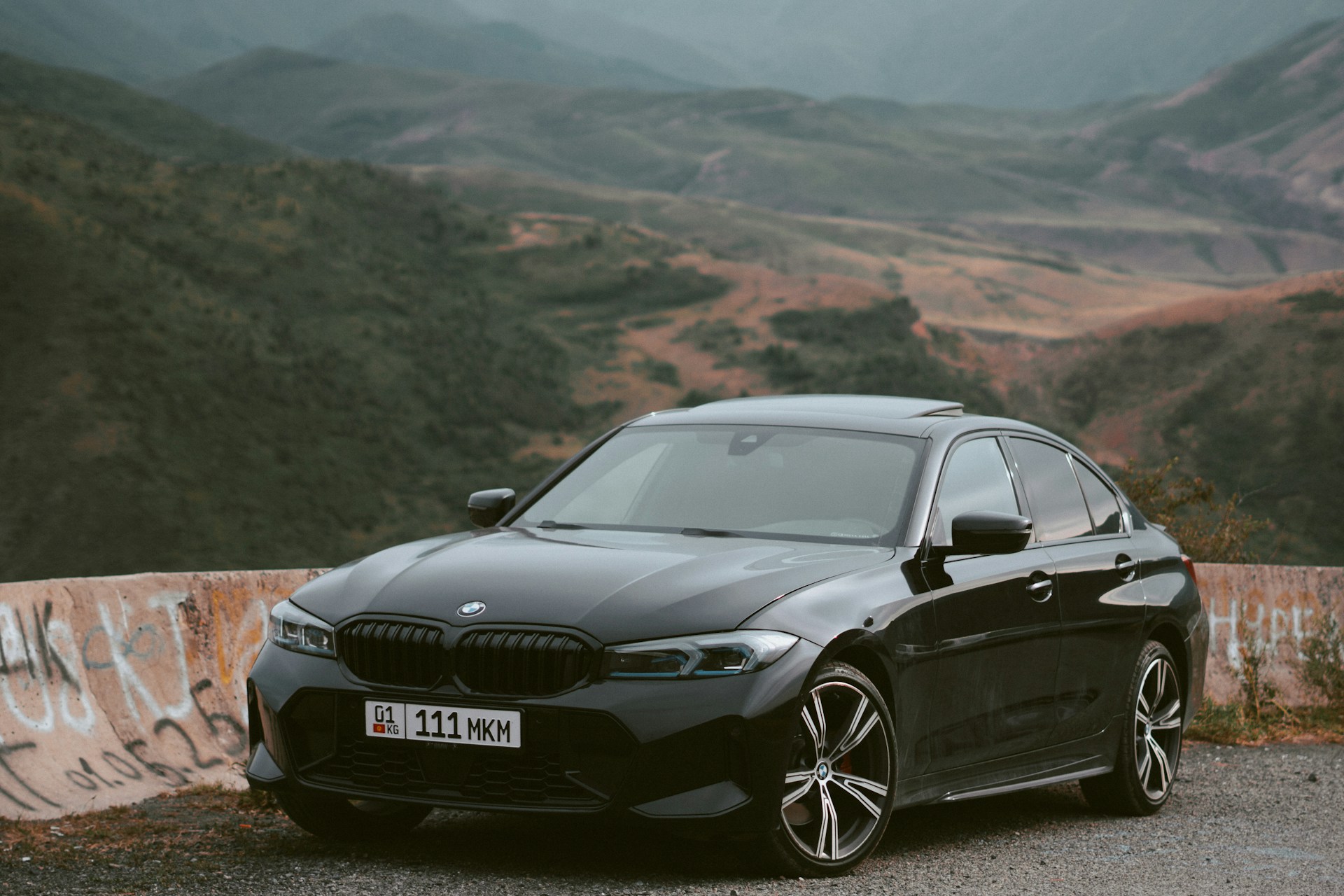 Modern black BMW on a mountain road